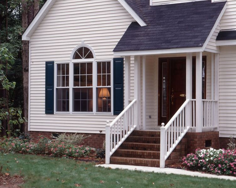 A white house with blue shutters and stairs