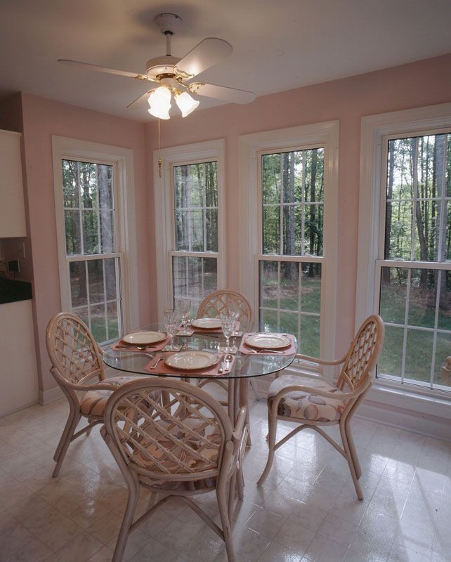 A dining room with a table and chairs and a ceiling fan