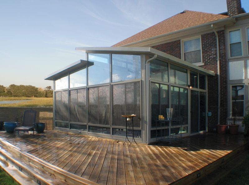 A house with a screened in porch and a wooden deck