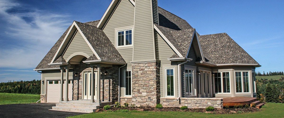 A large house is sitting on top of a lush green field.