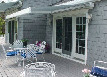 A patio with a table and chairs under an awning