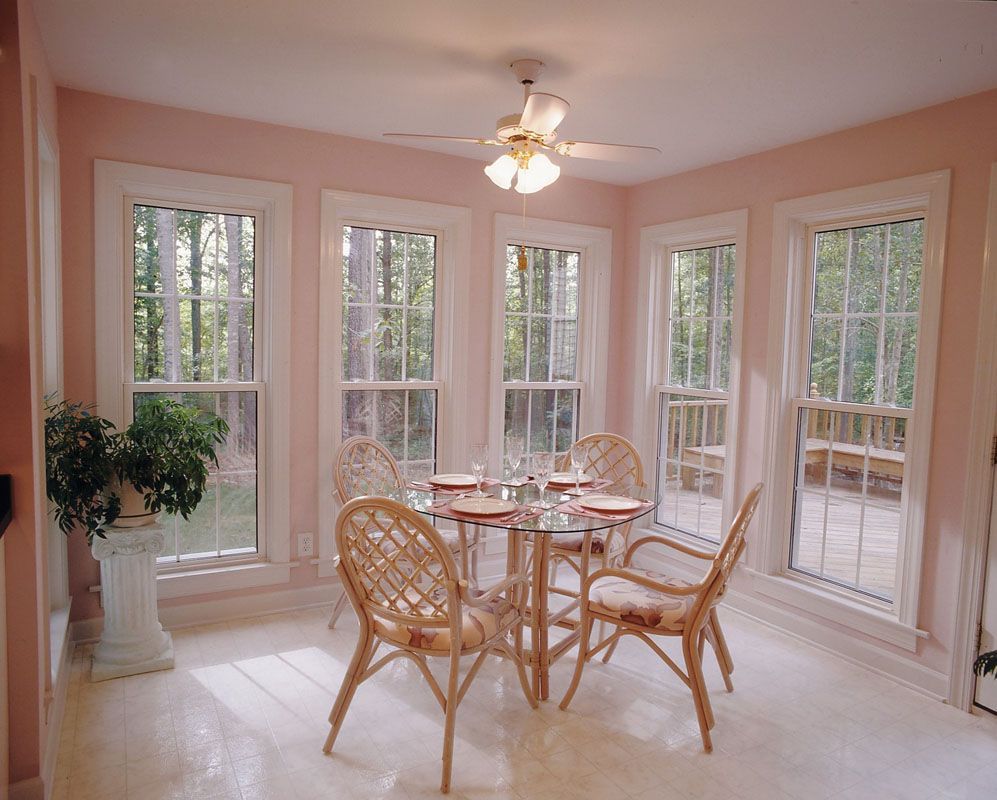 A dining room with a table and chairs and a ceiling fan