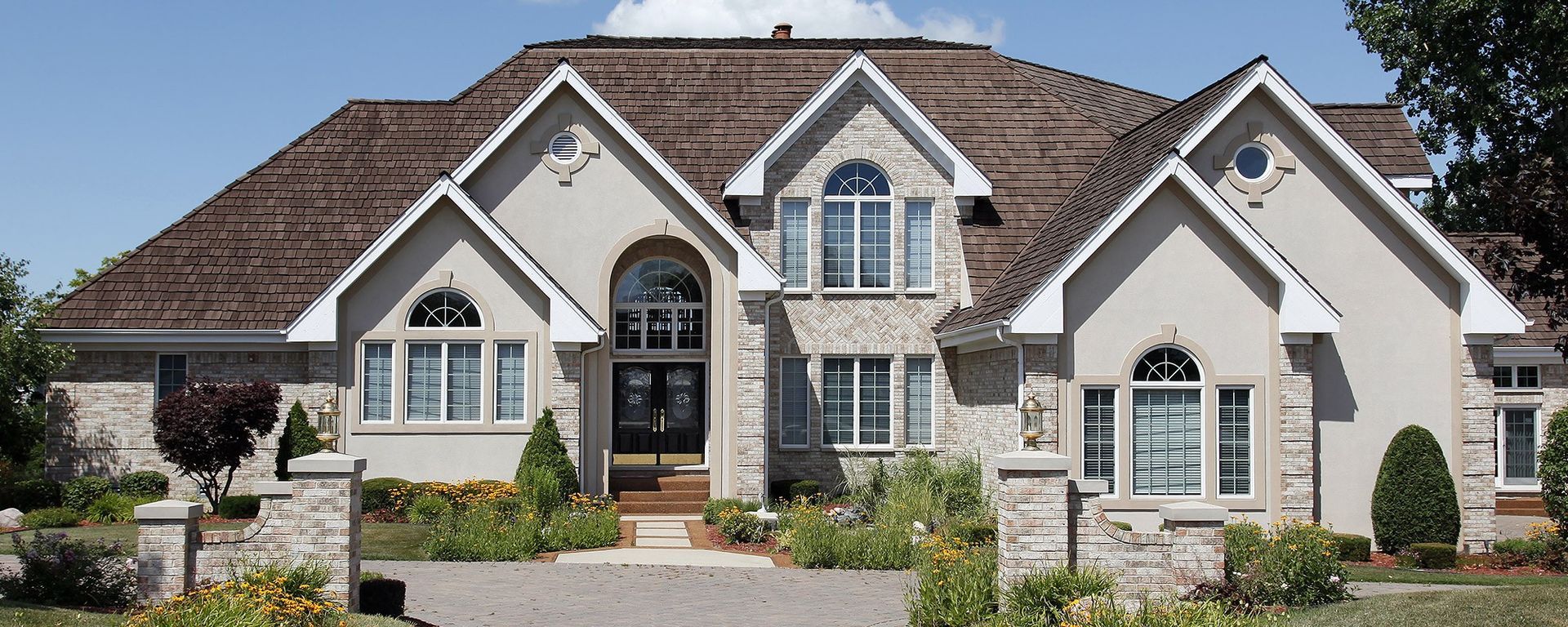 A large white house with a brown roof and a lot of windows