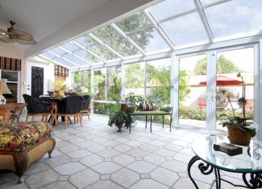A living room with a table , chairs , and a ceiling fan.