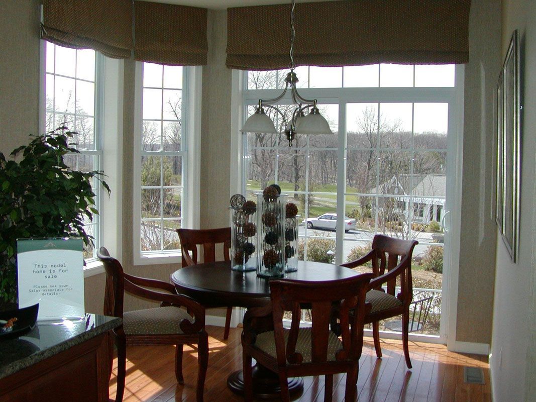A dining room with a table and chairs and a large window