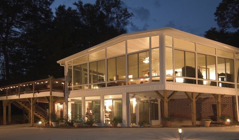 A house with a lot of windows is lit up at night