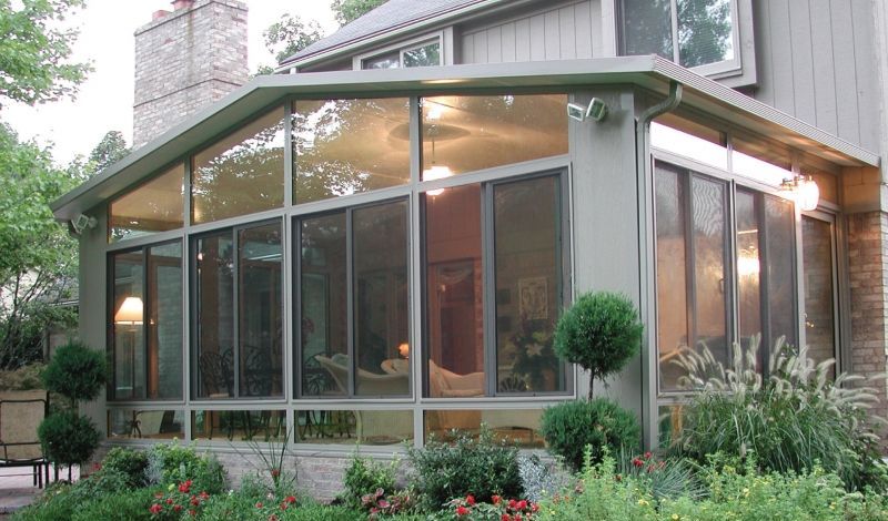 A house with a screened in porch with lots of windows