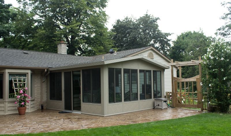 A house with a screened in porch and a patio