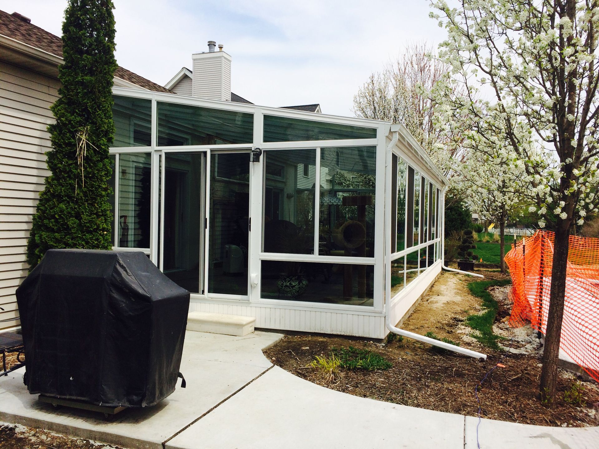 A sunroom with a grill in front of it.