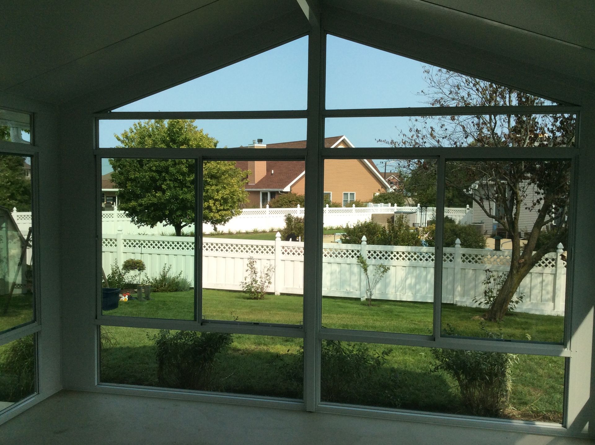 A screened in porch with a view of a backyard.