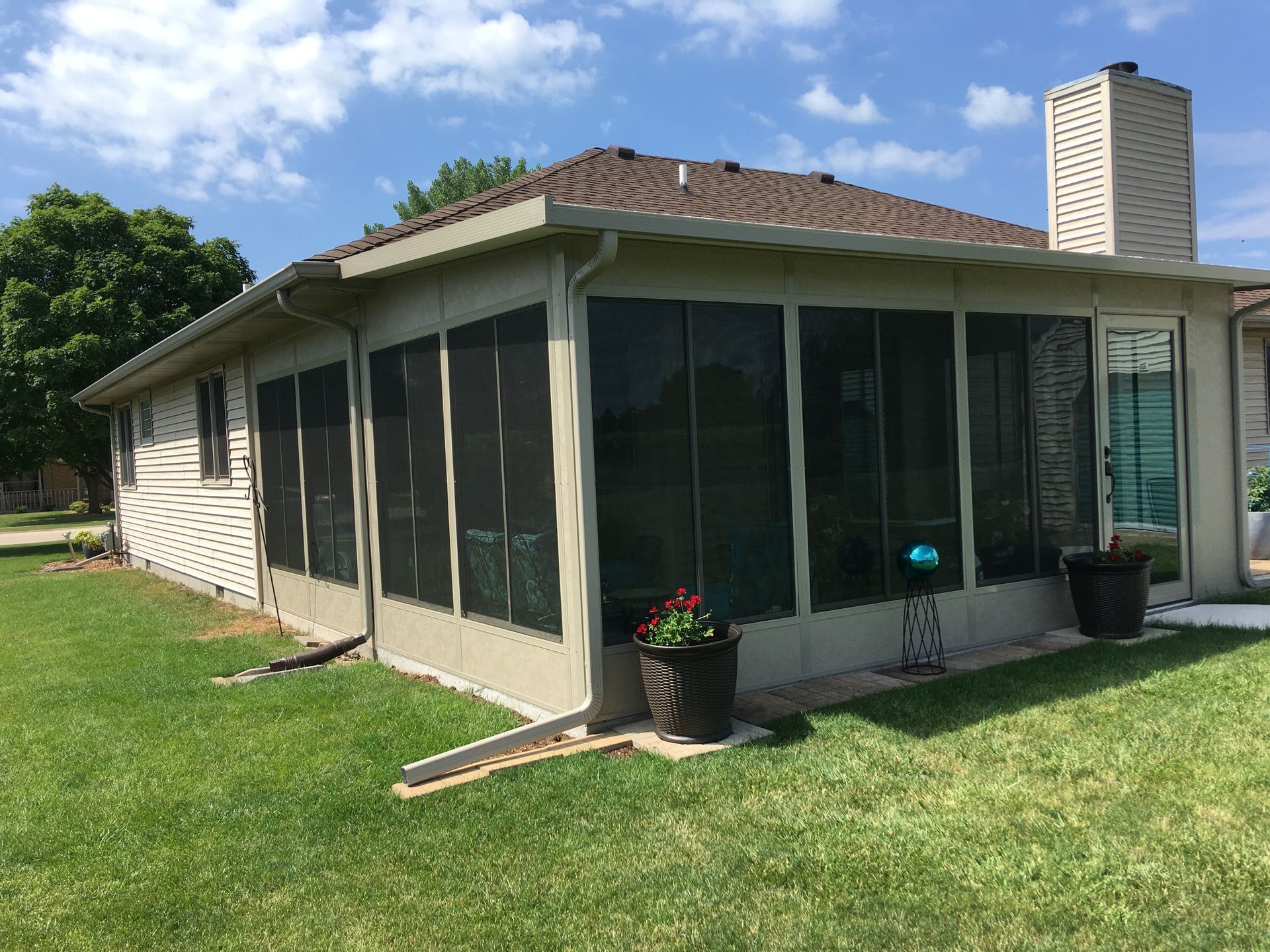 A house with a screened in porch in the backyard.