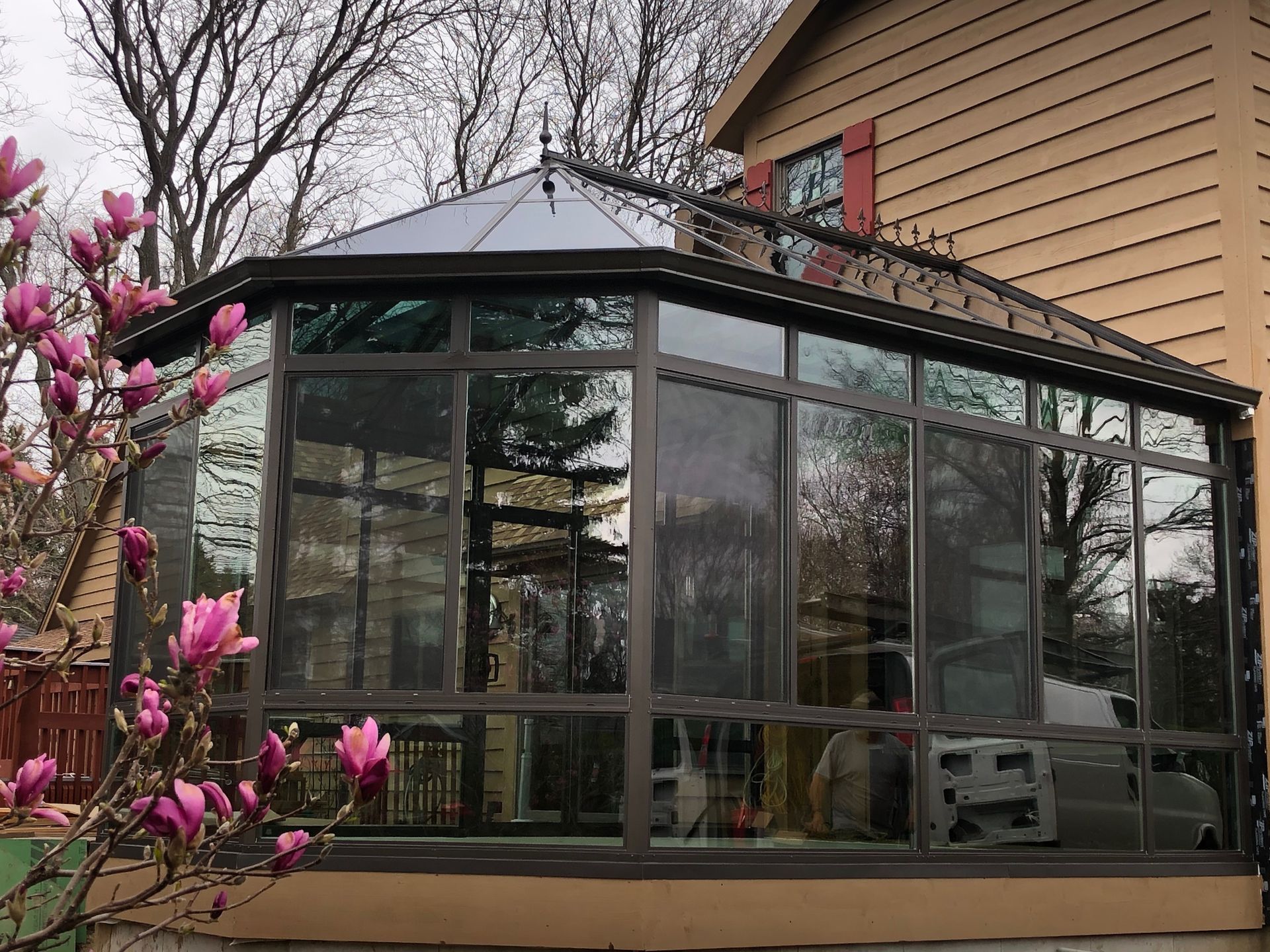 A house with a screened in porch and a tree in front of it.