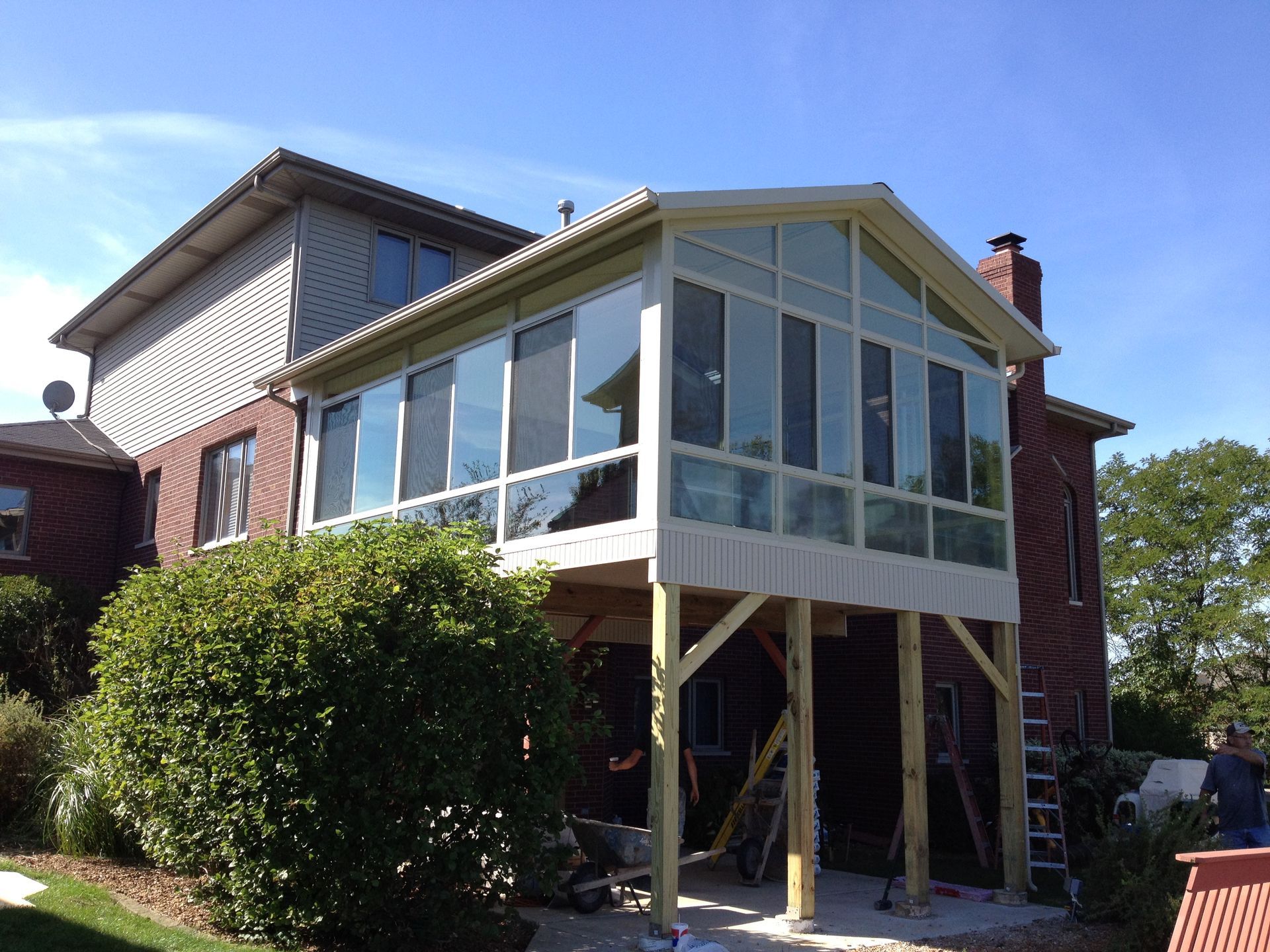A house with a screened in porch that is being built.