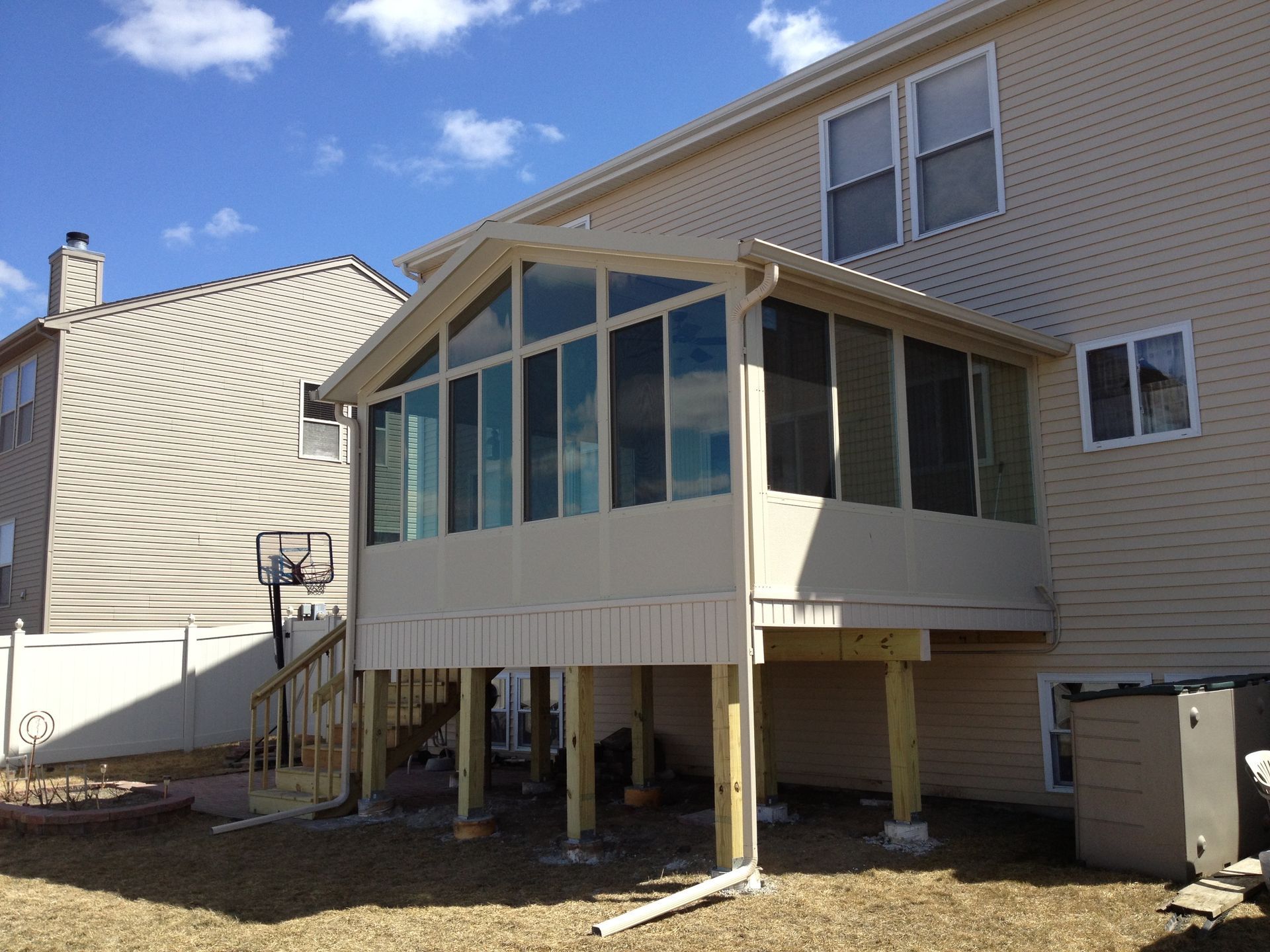 A house with a screened in porch and stairs.