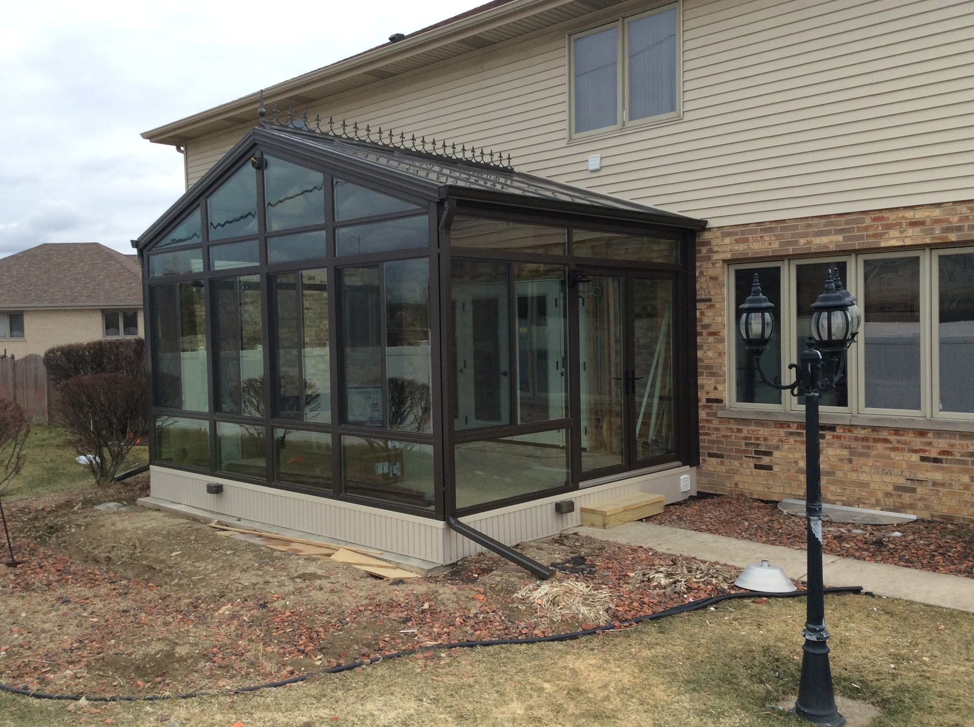 A sunroom is being built on the side of a house.
