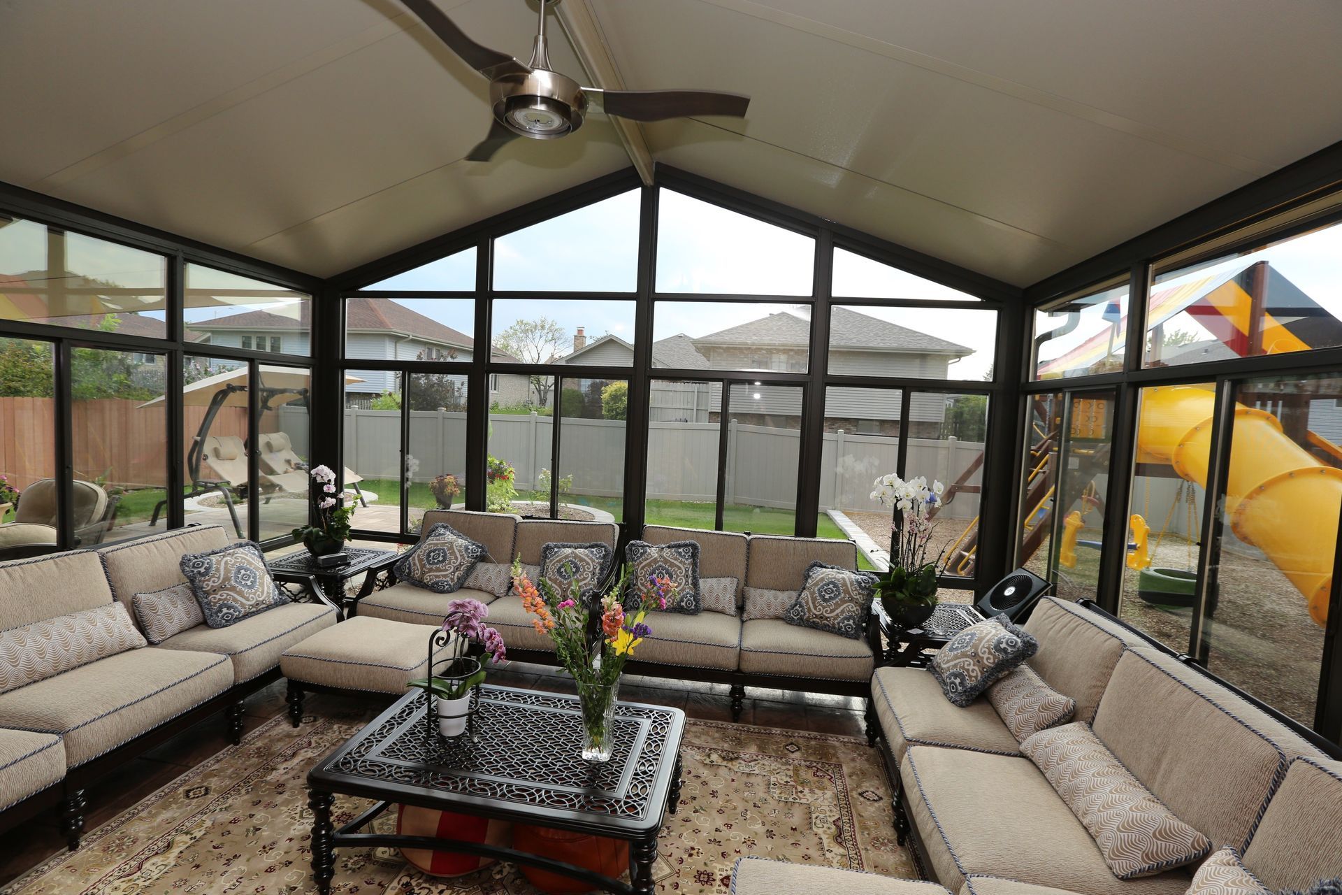 A living room with a lot of furniture and a ceiling fan.