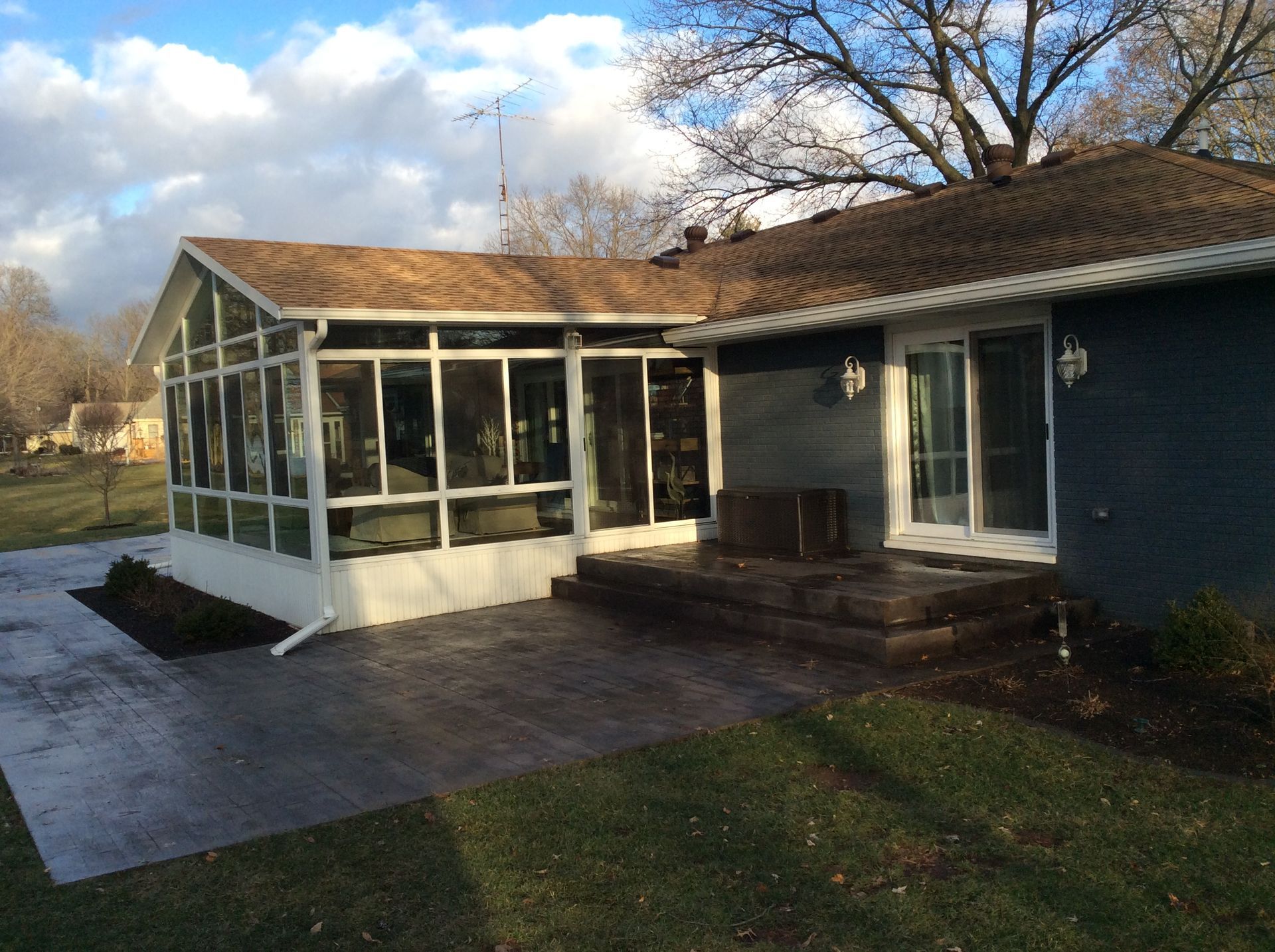 A house with a screened in porch and patio.