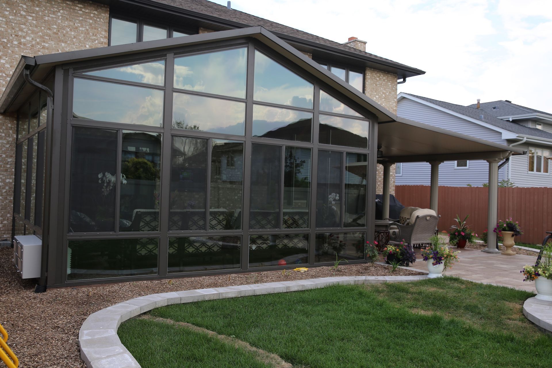 A house with a screened in porch in the backyard.