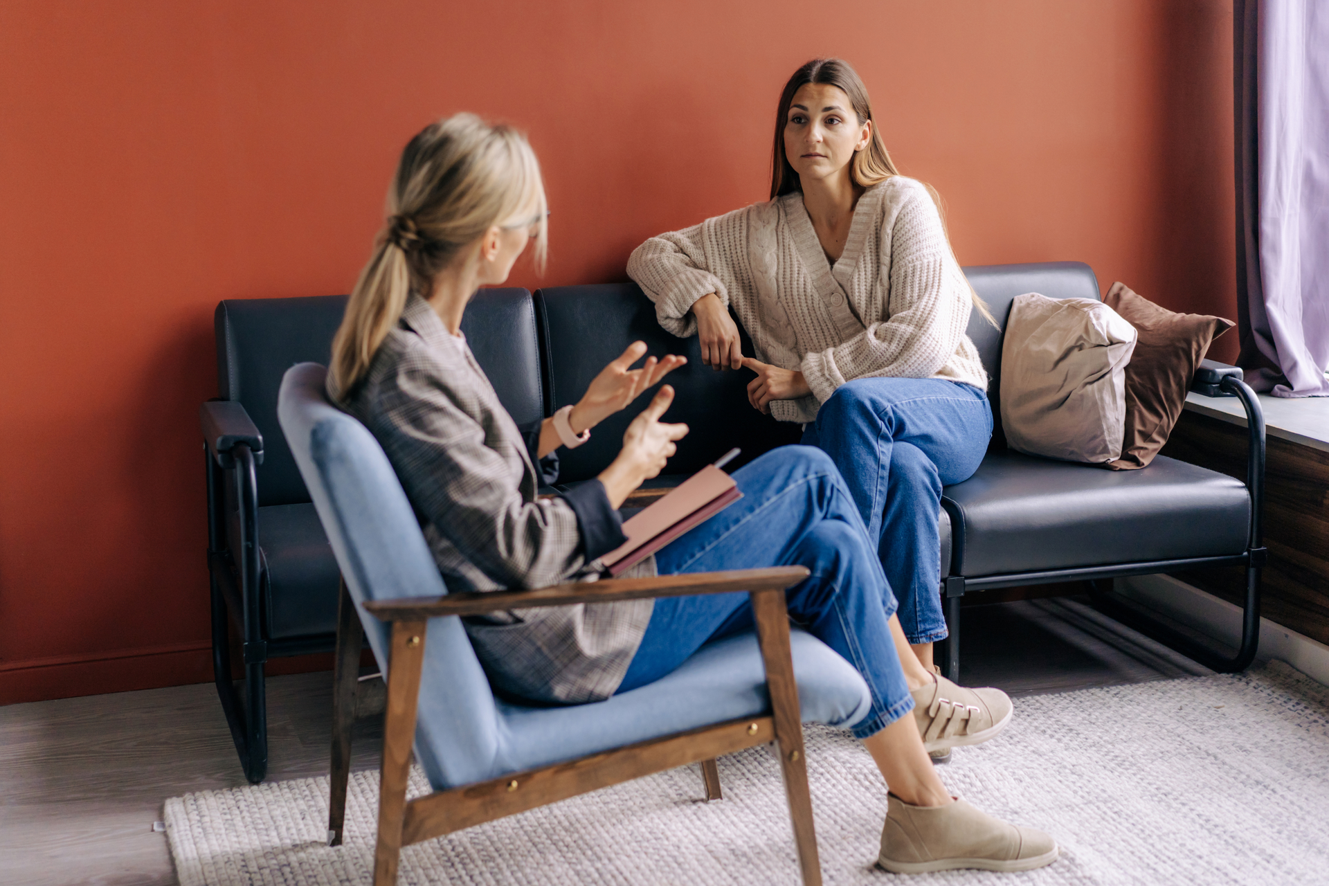 A person sitting in a therapy session discussing anxiety with a mental health professional.