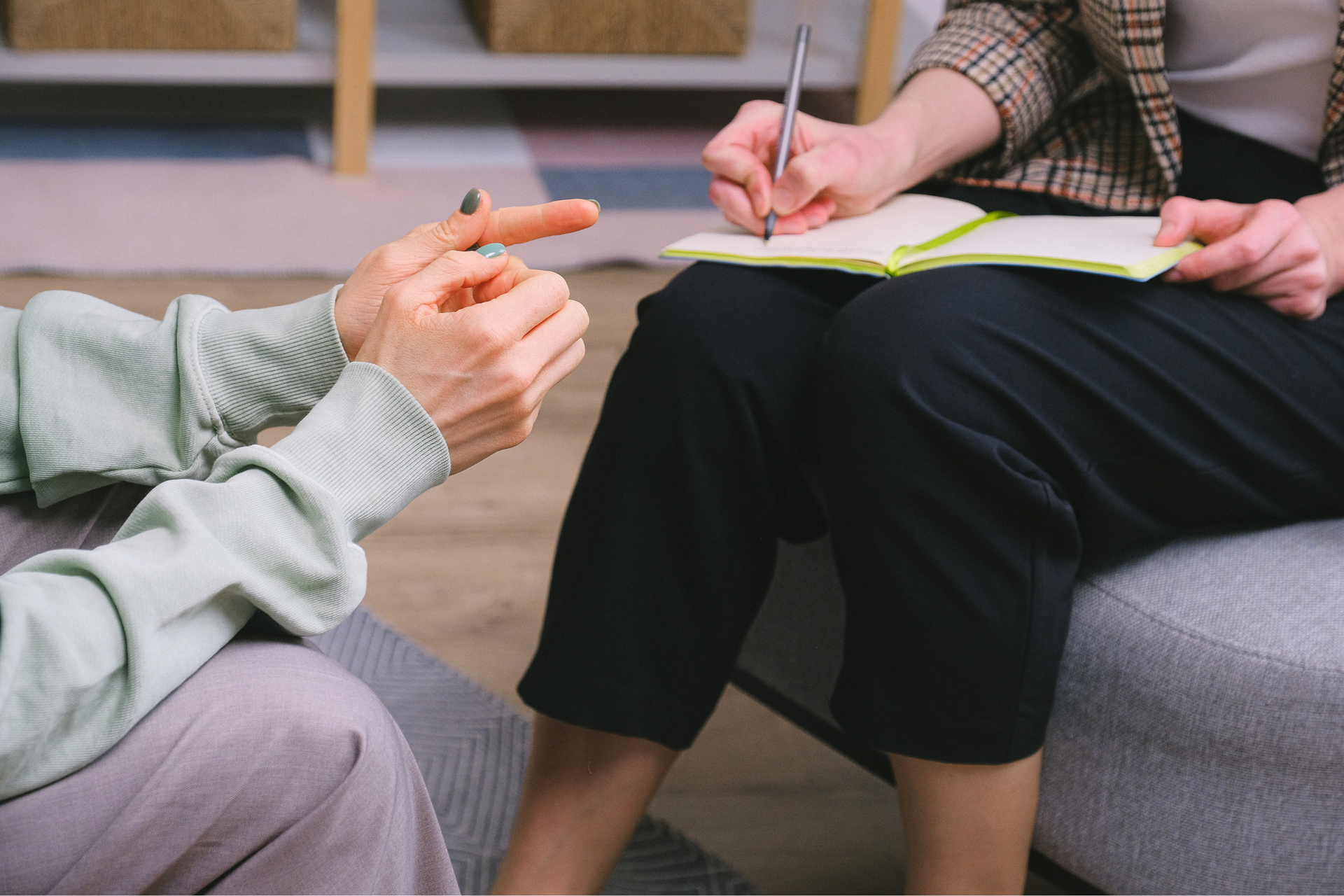 a counselor takes notes as a patient talks