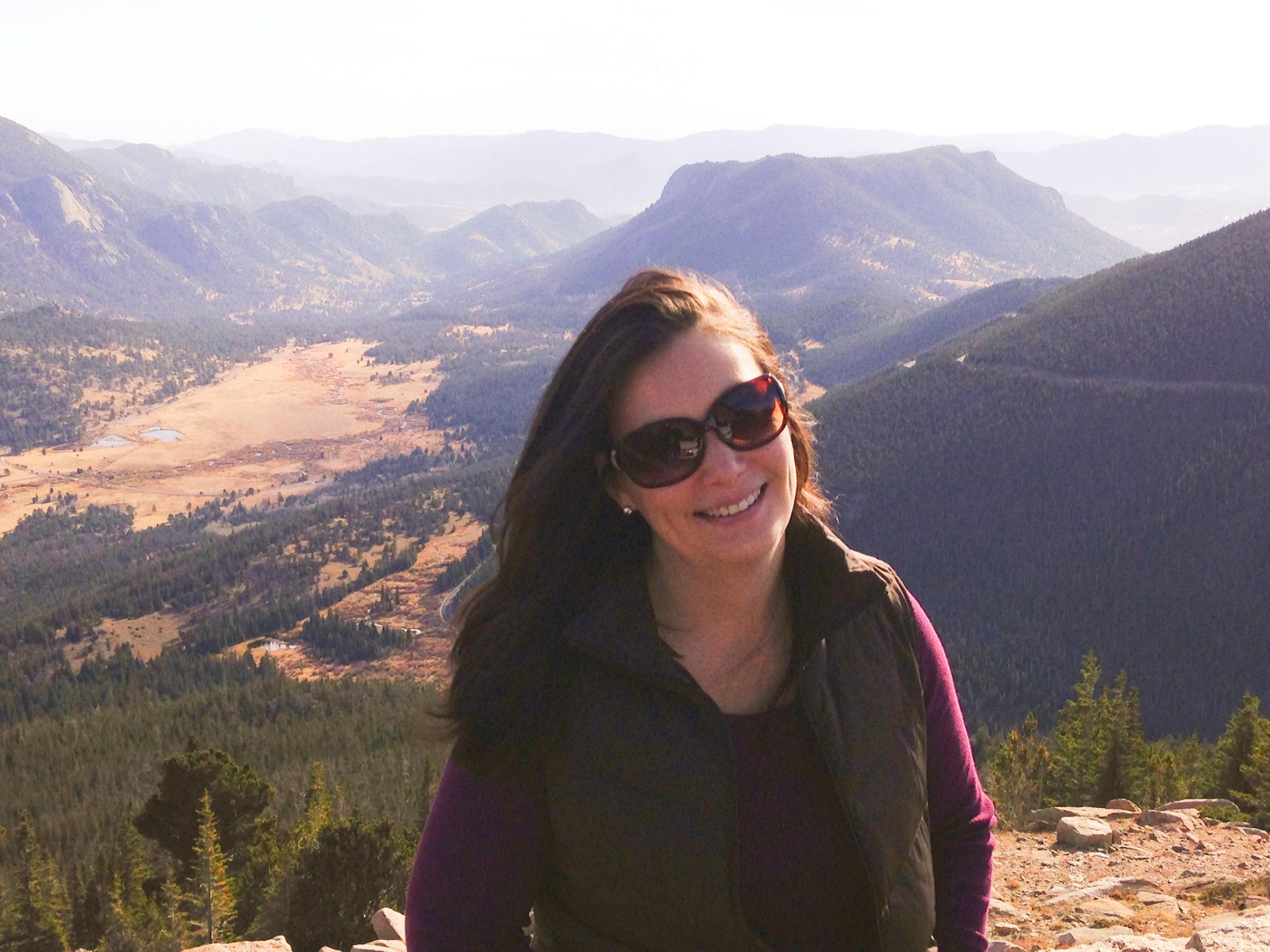 A photo of Neeley smiling with majestic mountains in the background, symbolizing strength. 