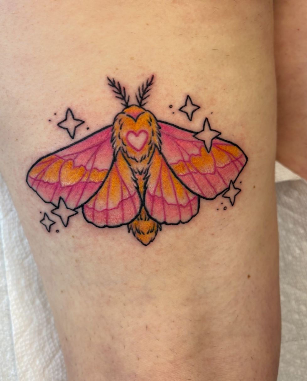 A woman has a tattoo of a moth with stars around it