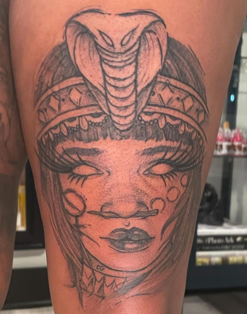 A woman has a tattoo of a snake on her head.