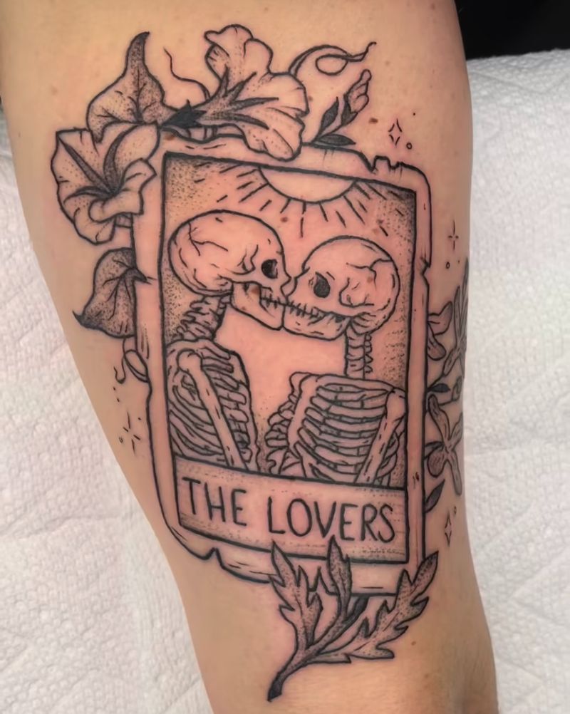 A tattoo of two skeletons kissing with the words the lovers