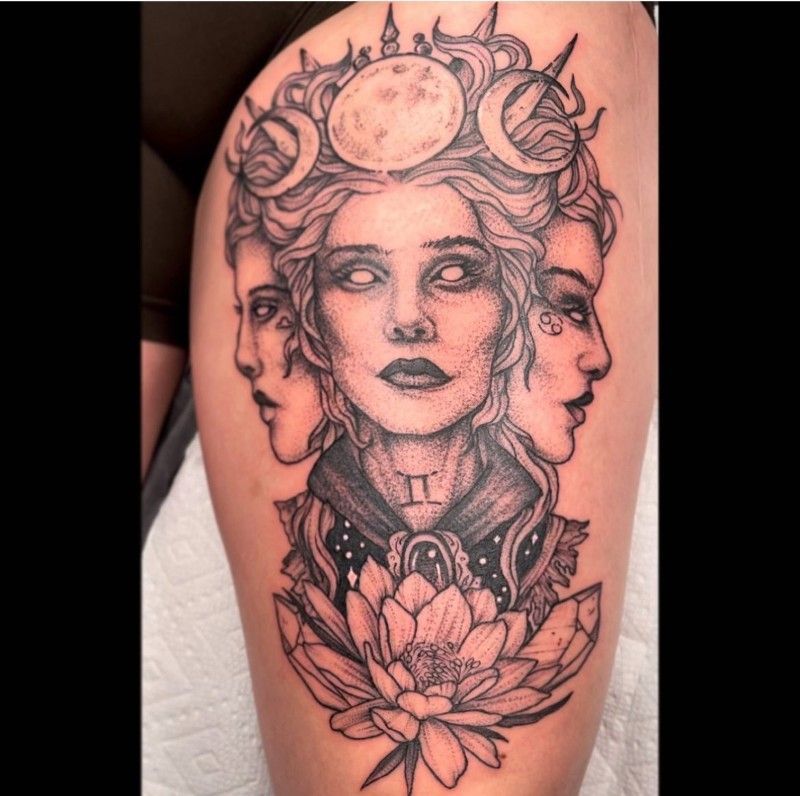 A black and white tattoo of a woman with three faces