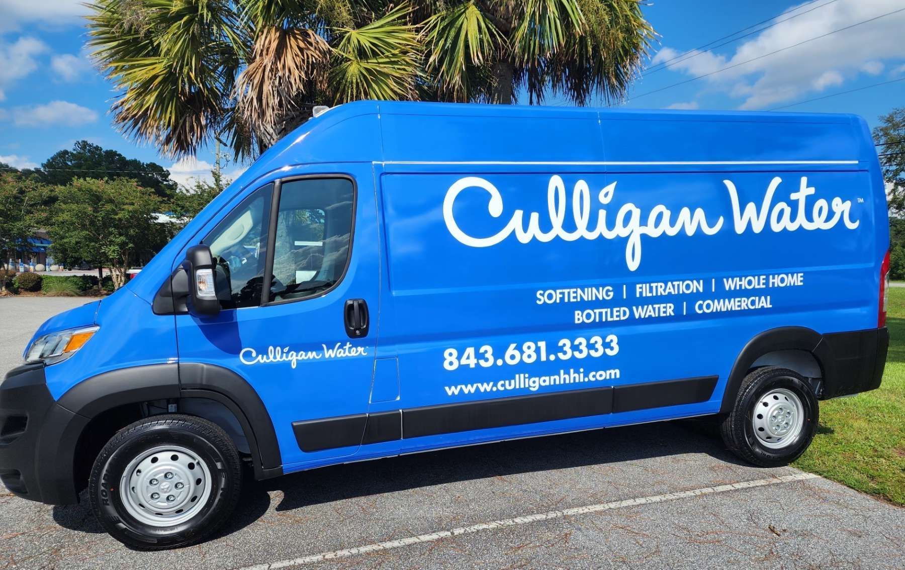 Blue Culligan Water van parked outdoors with text and phone number.