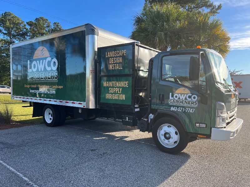 Green LowCo Elements landscaping truck parked outdoors.