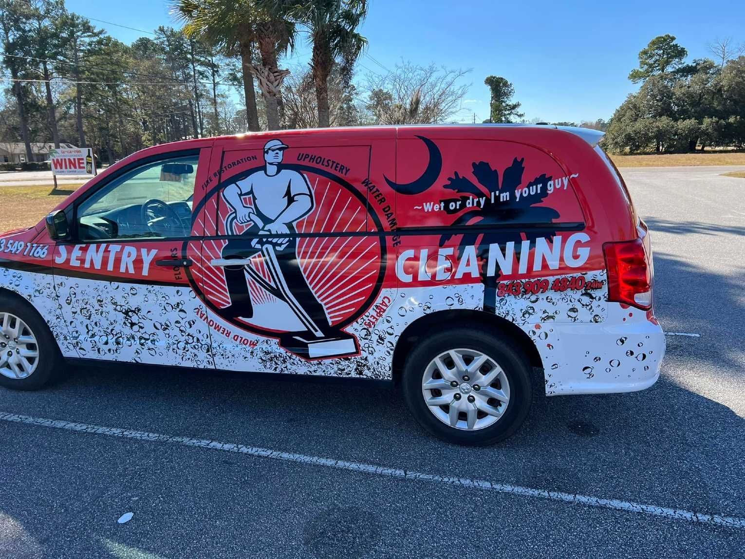 Red and white Sentry Cleaning van with logo of a person using a carpet cleaner.