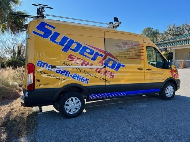 Yellow Superior Services van parked outside on a sunny day with a blue and white striped accent.