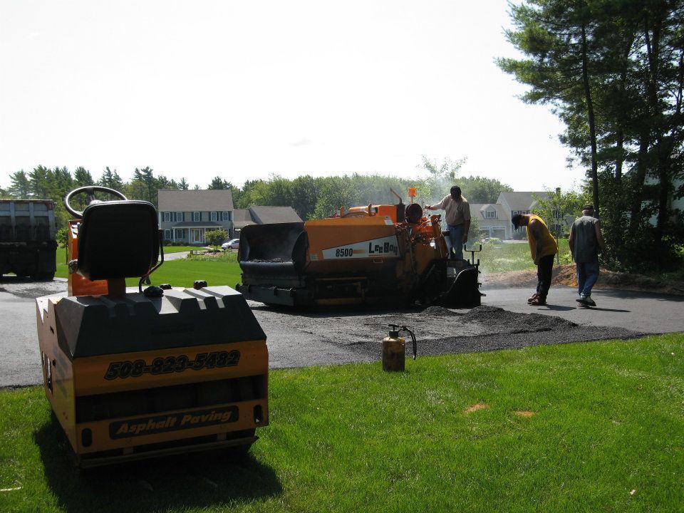 A group of people are working on an asphalt road