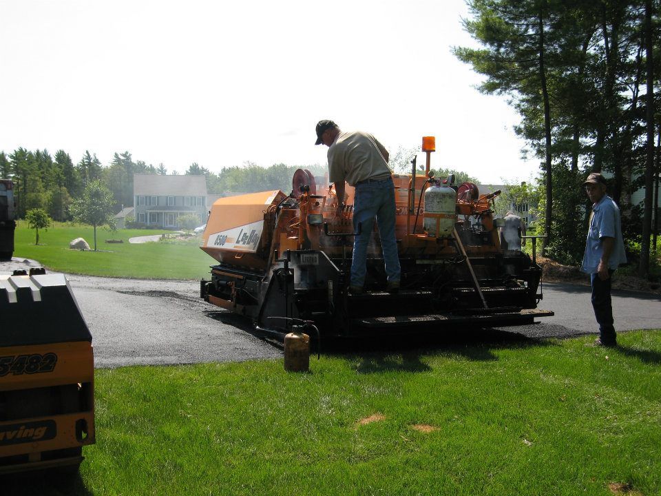 A man standing next to a machine that says ' asphalt ' on it