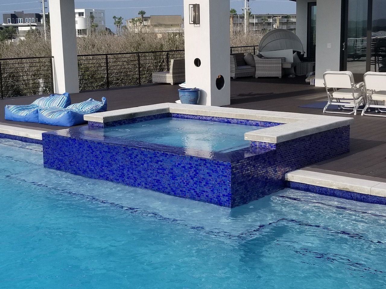 A large swimming pool with a hot tub in the middle