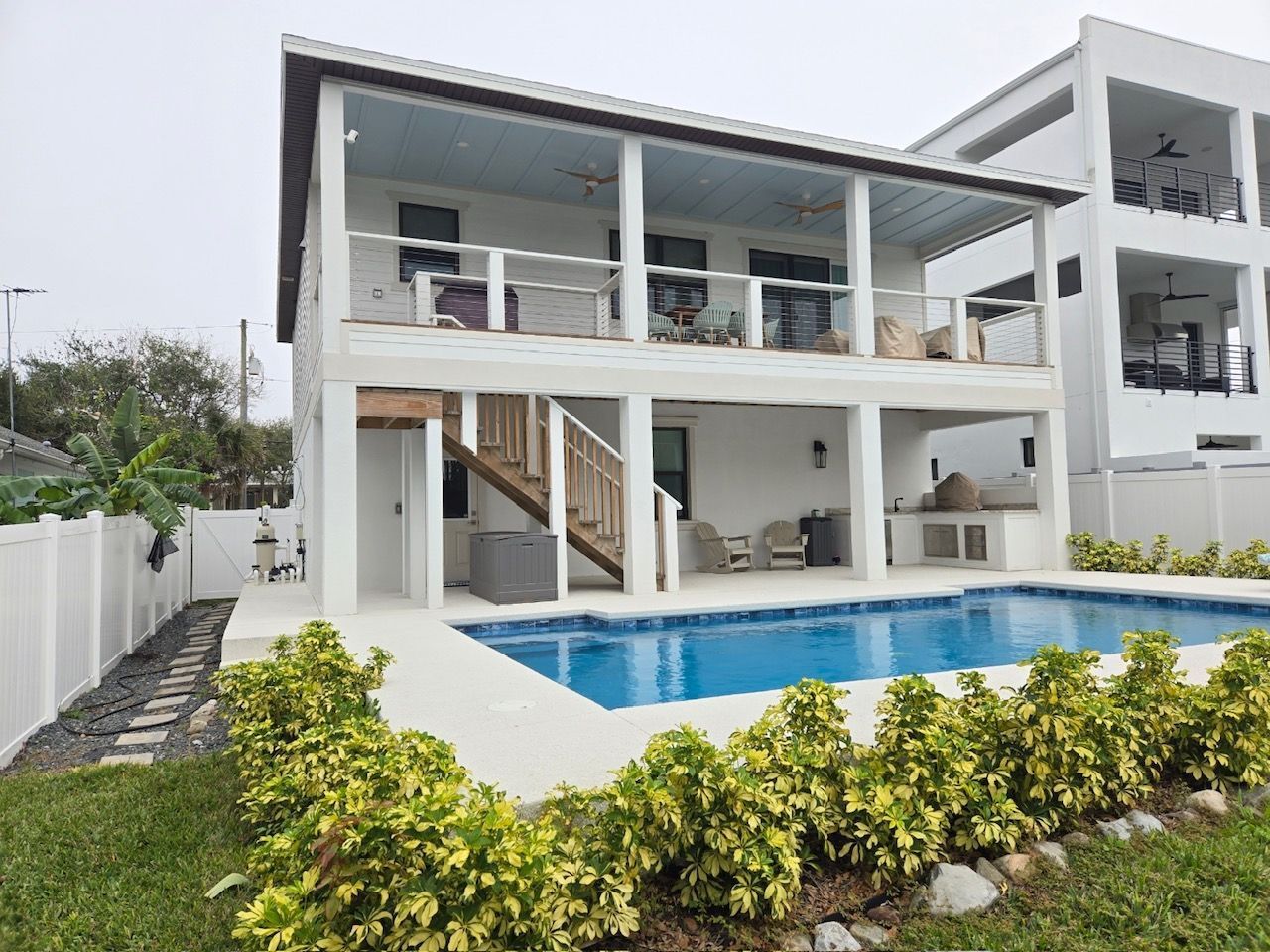 A large white house with a large swimming pool in front of it