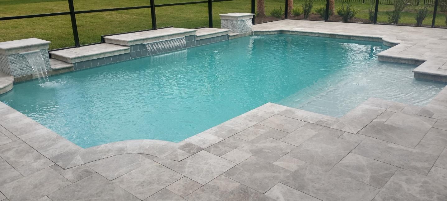 A large swimming pool with a waterfall in the backyard