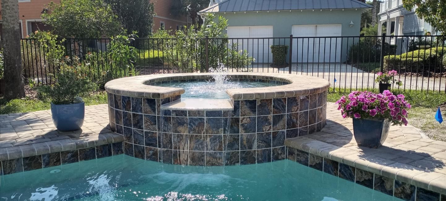 A swimming pool with a hot tub in the middle of it