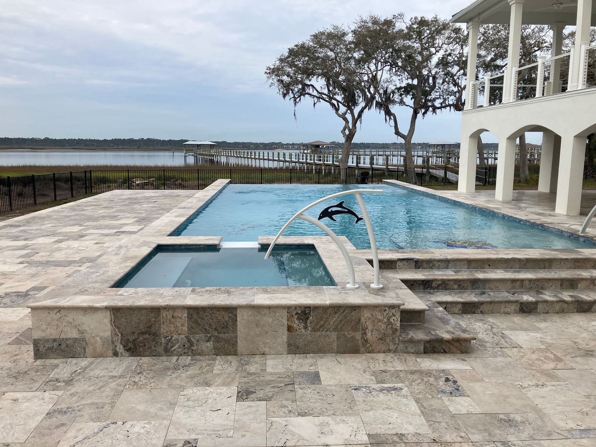 A large swimming pool with a hot tub next to it