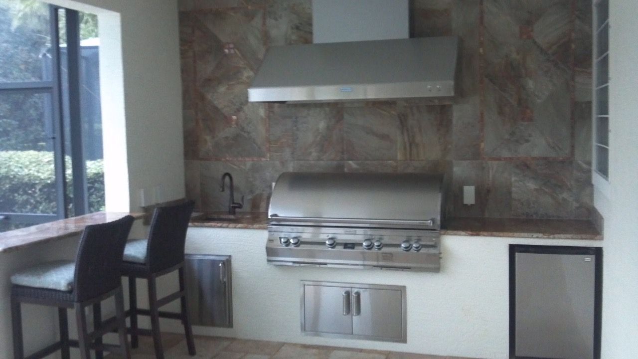 A kitchen with a stainless steel grill and a sink