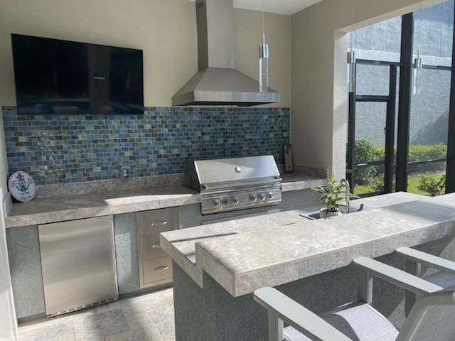 A kitchen with stainless steel appliances and a large window