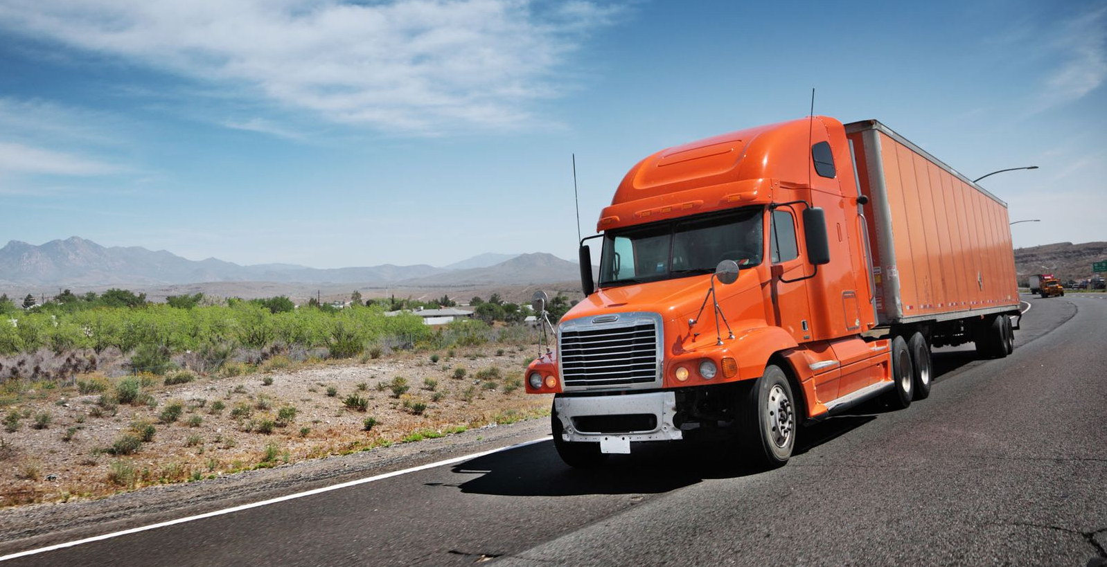 Orange tractor trailer on the road