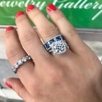 Hand wearing three diamond rings, showing off the jewelry.