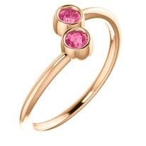 Rose gold bypass ring with two pink gemstones.