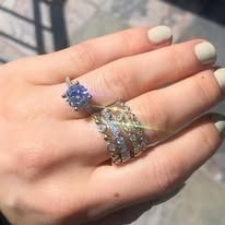 Hand wearing two diamond rings, one large solitaire and a pave band.