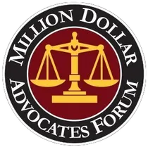 Million Dollar Advocates Forum logo: scales of justice in gold on burgundy circle, surrounded by black ring with white text.