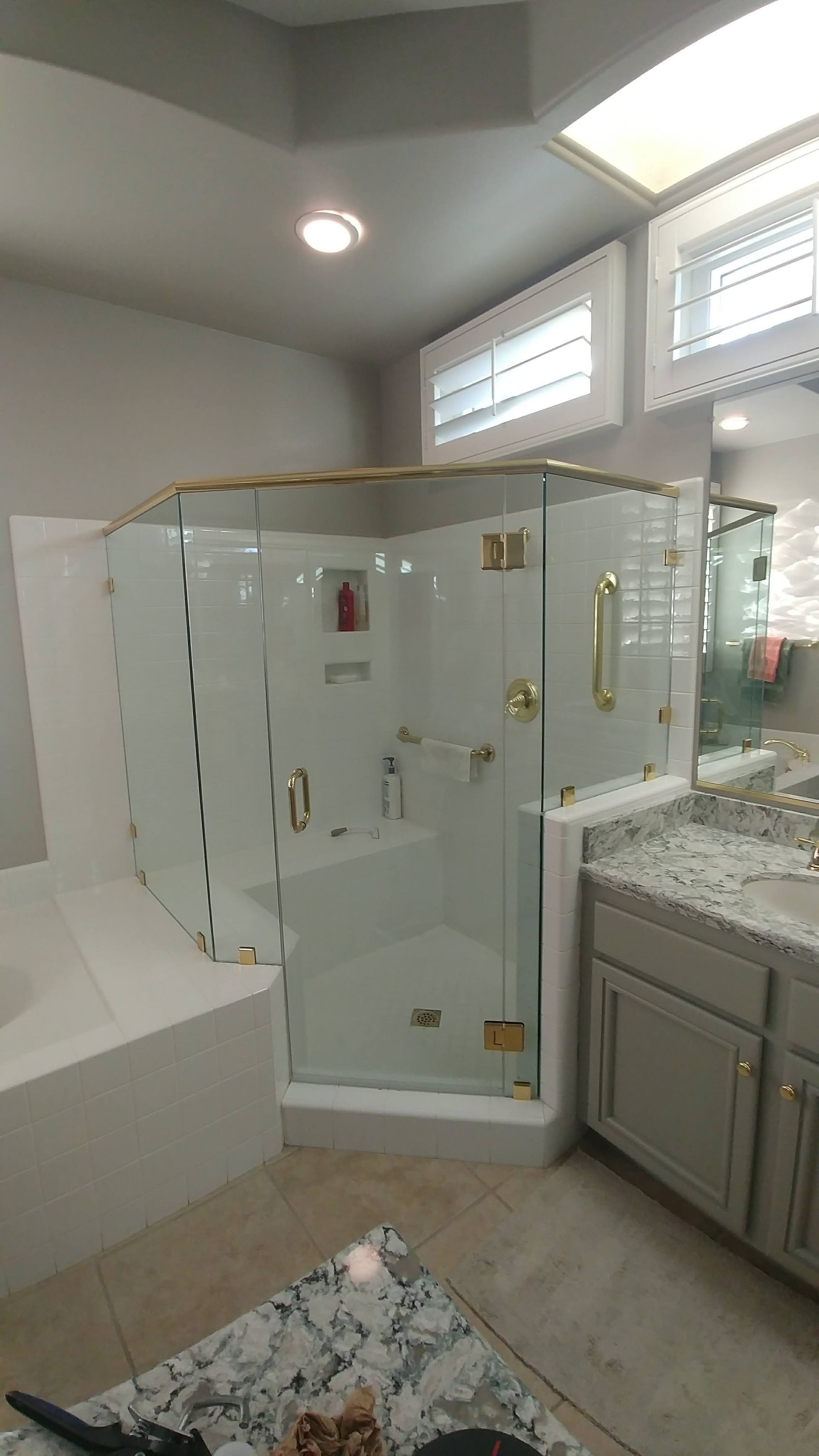 A bathroom with a walk in shower and a bathtub.