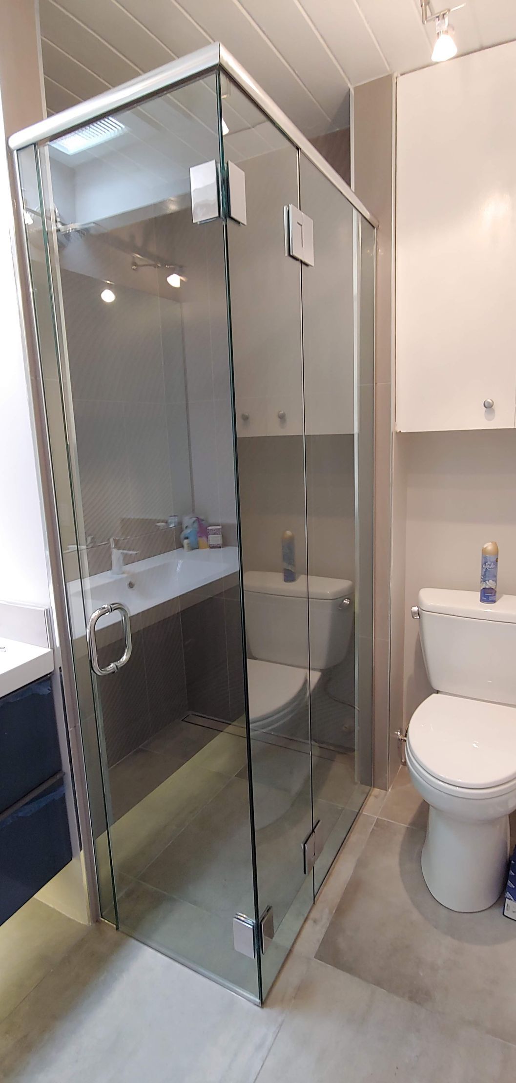 A bathroom with a toilet, sink, and shower stall.