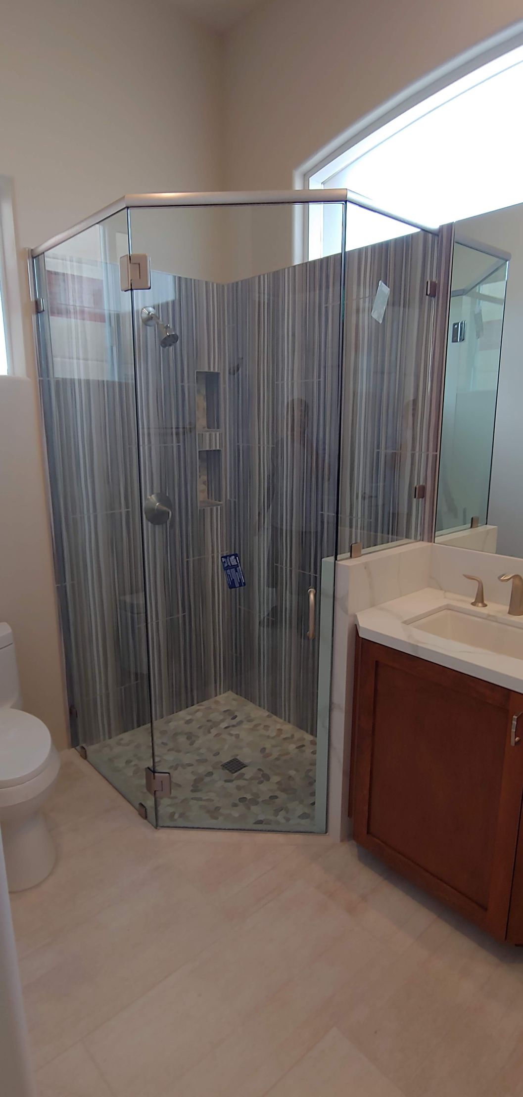 A bathroom with a walk-in shower, sink, and toilet.